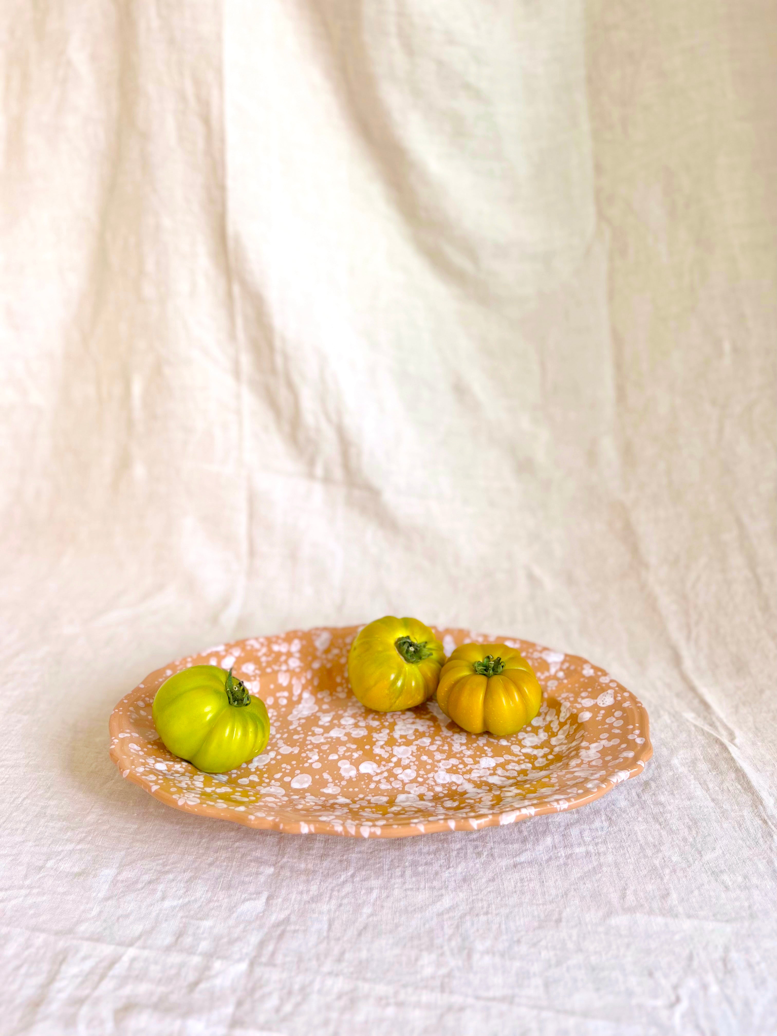 brown and white oval spatterware platter 14" on white cloth