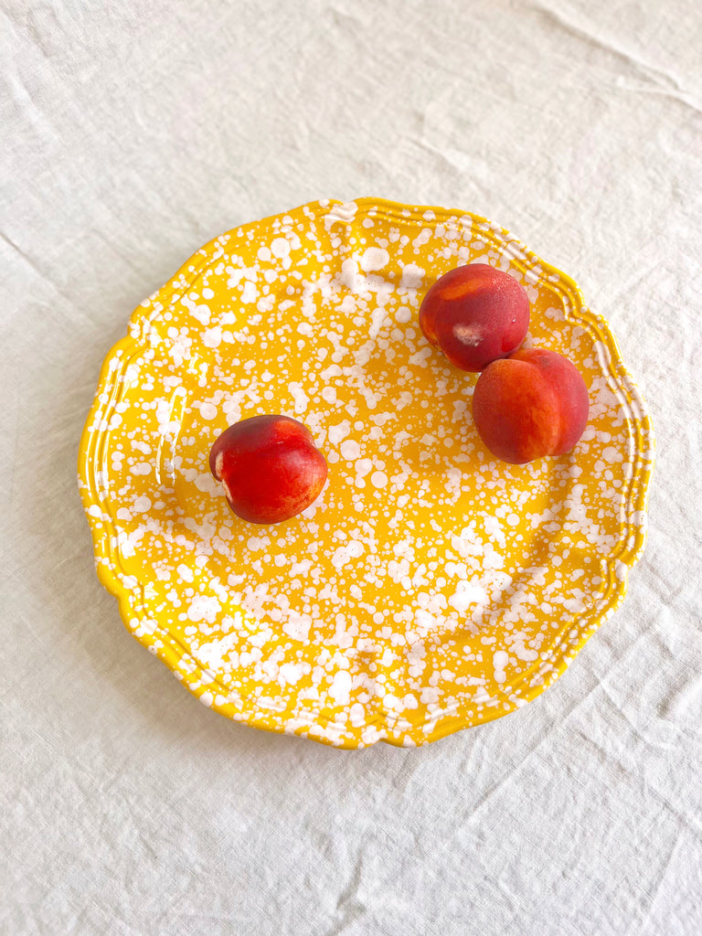 yellow and white round spatterware platter 14" on table
