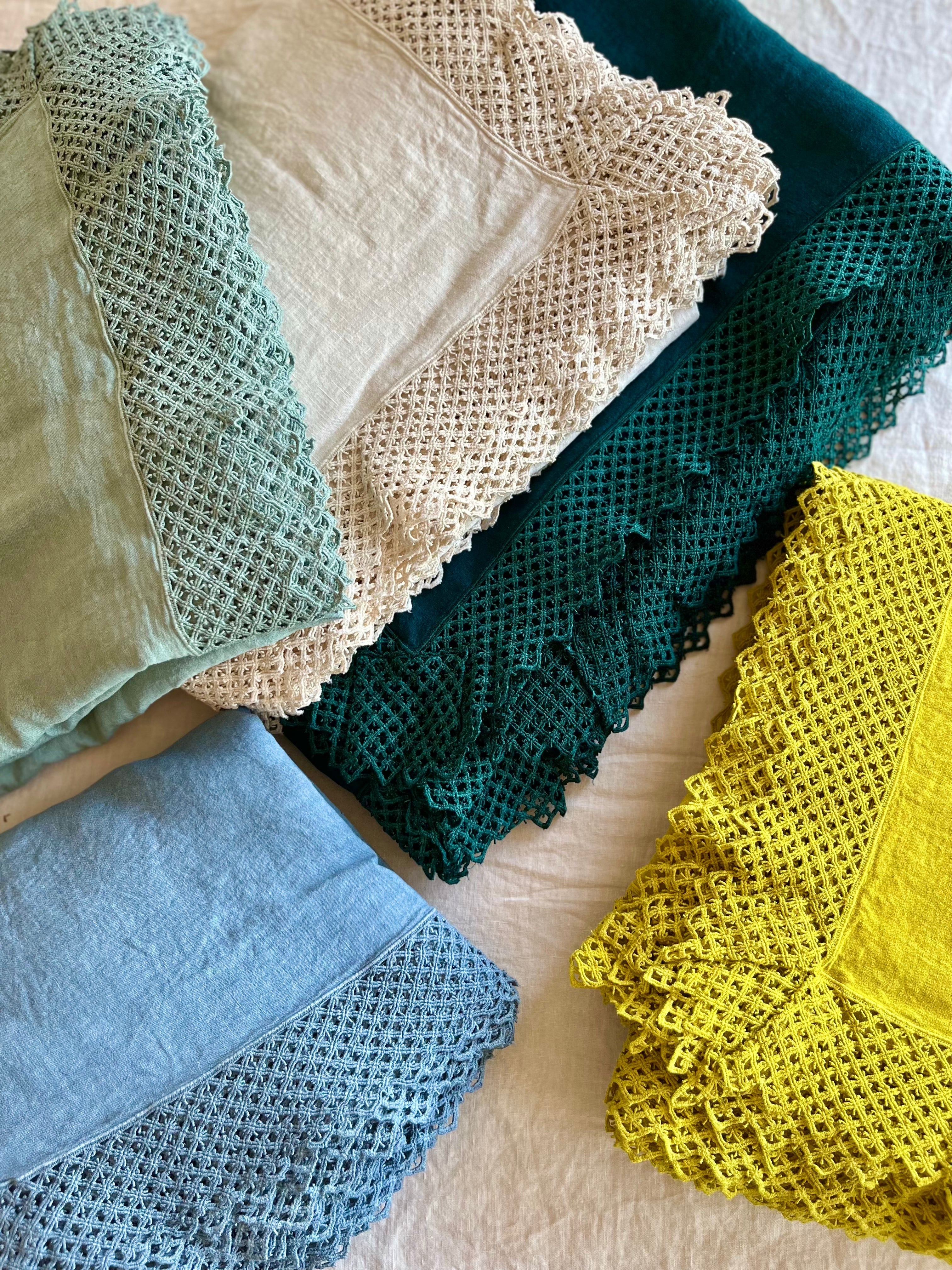 teal linen tablecloth with macrame trim shown with other color options