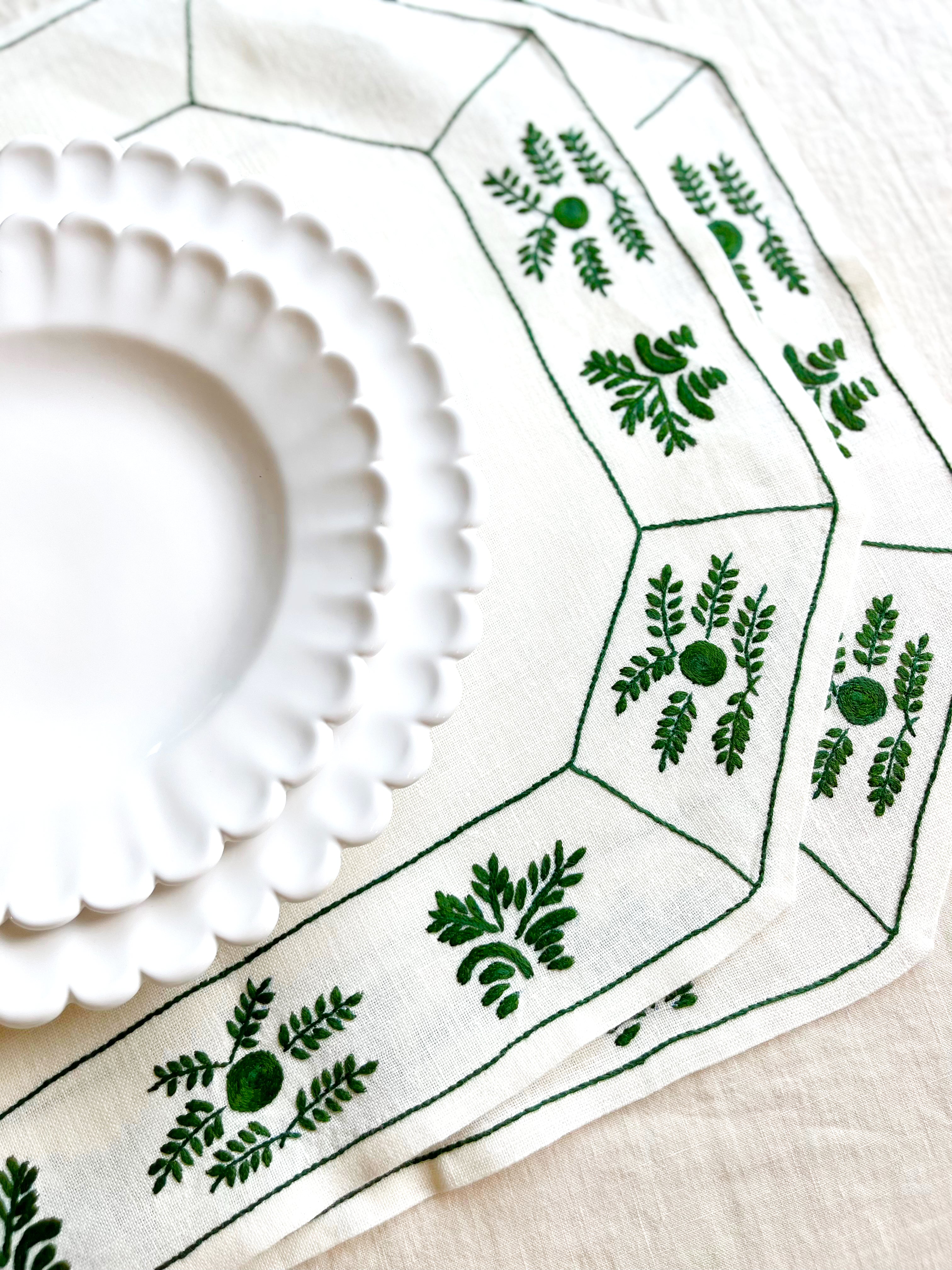 octagonal white linen placemat with olive green embroidery 19.5" by 16" detail view