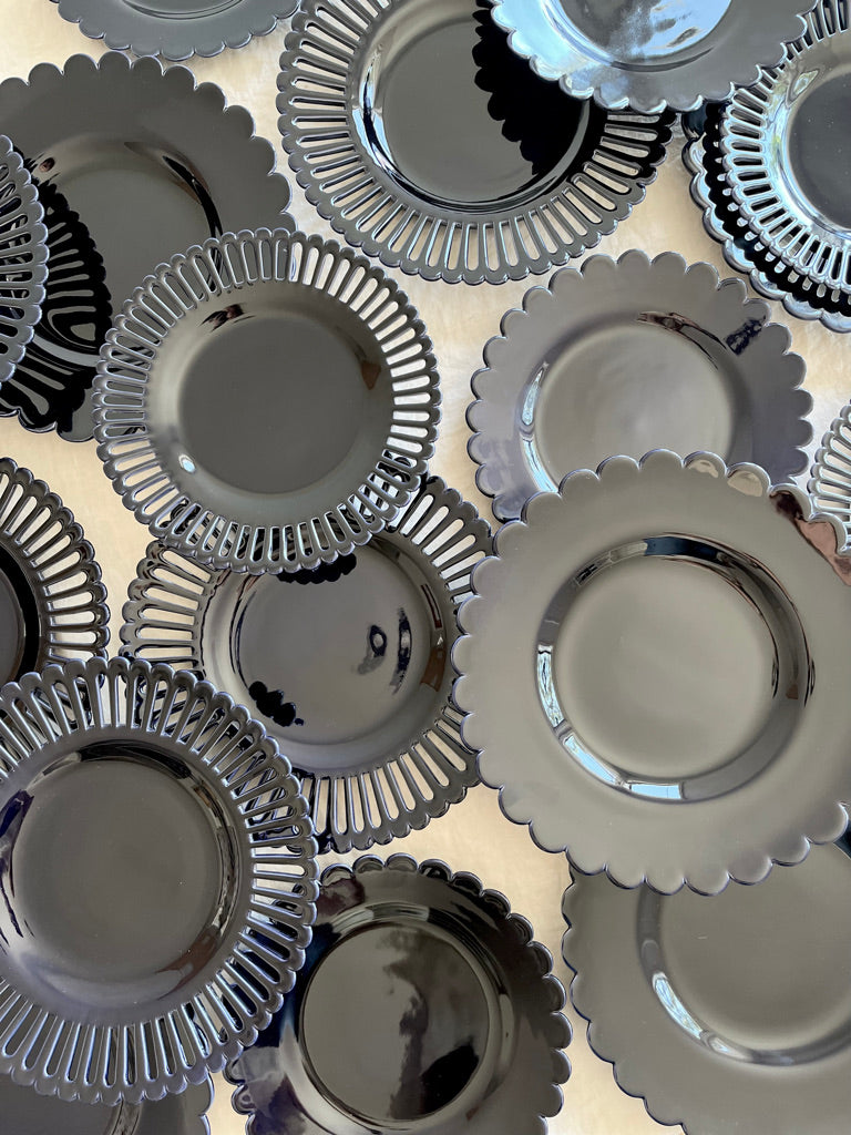 dark blue salad plate with scalloped edge on white table