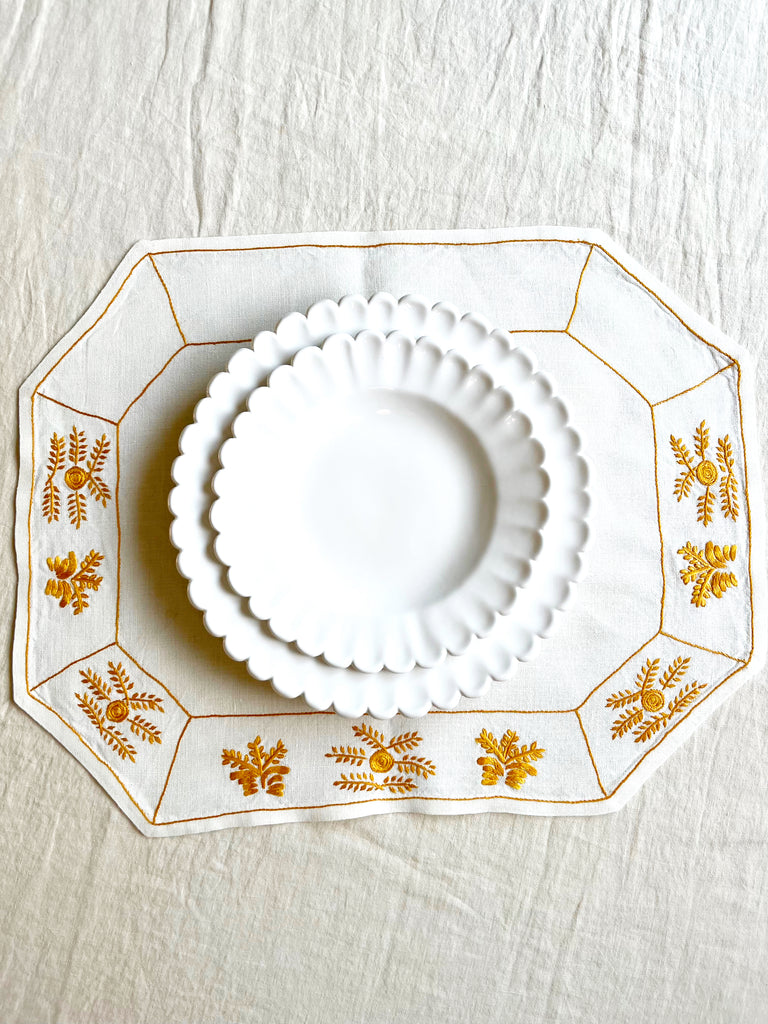 octagonal white linen placemat with gold embroidery 19.5" by 16" with placesetting
