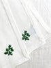 white hand embroidered linen napkins with dark green leaves in corner 16 inches square fanned out on table