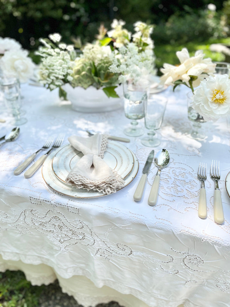 white jardiniere planter with scalloped edge on lace tablecloth