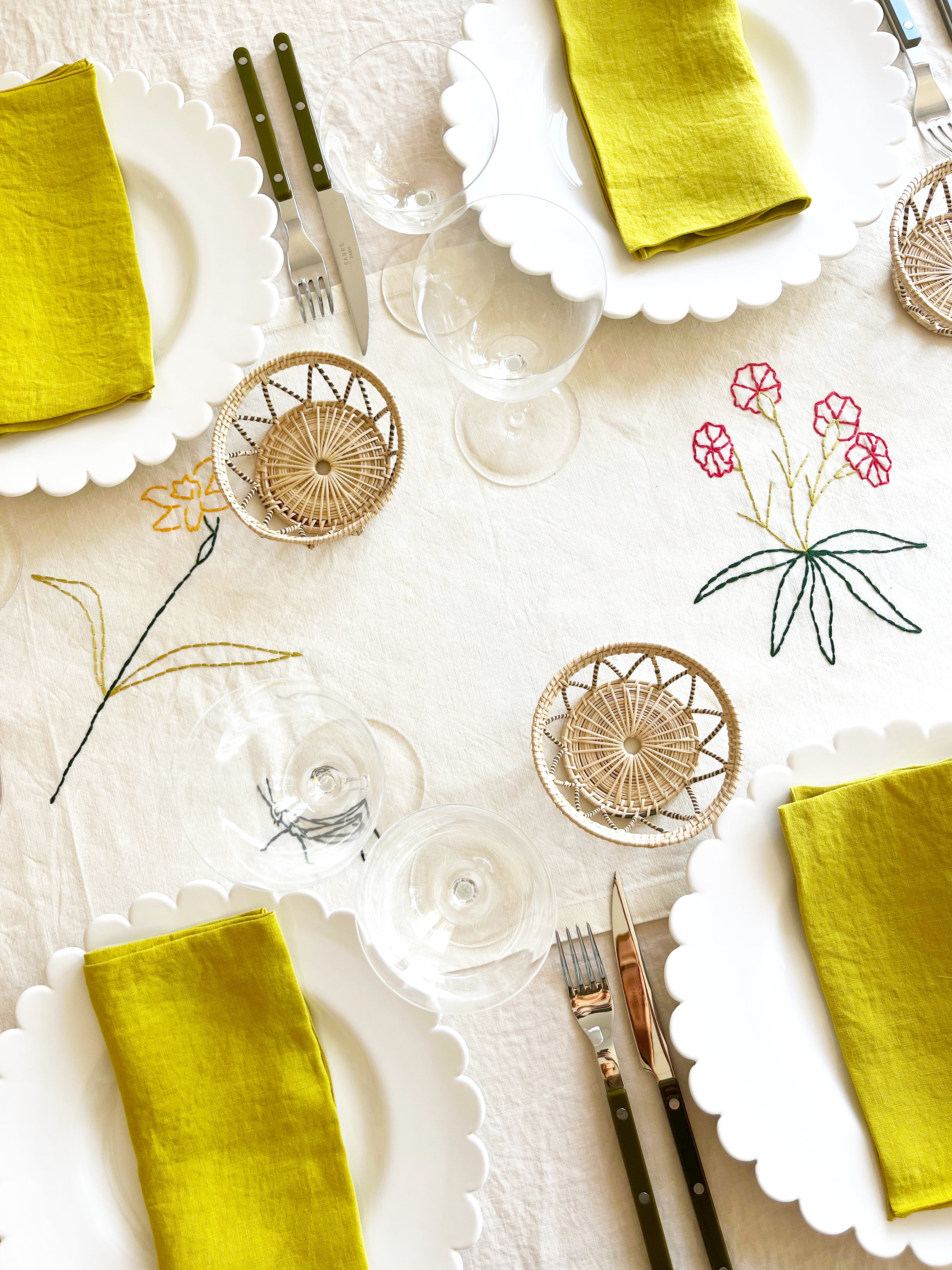 hand painted white salad plate with scalloped edge on embroidered tablecloth