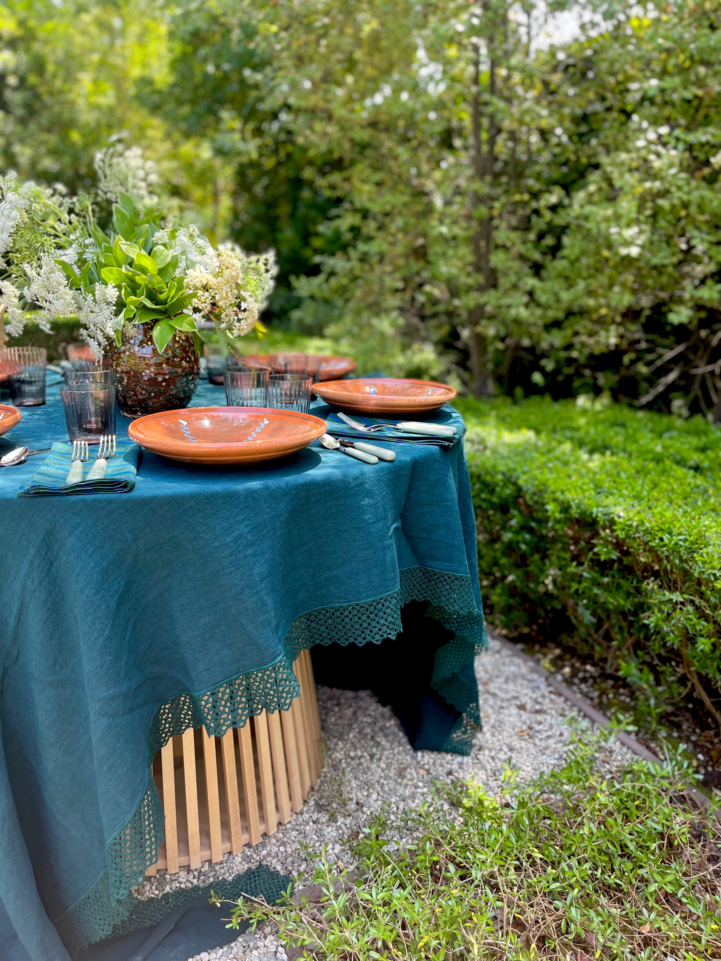 teal linen tablecloth with macrame trim on table