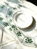 octagonal white linen placemat with olive green embroidery 19.5" by 16" on table