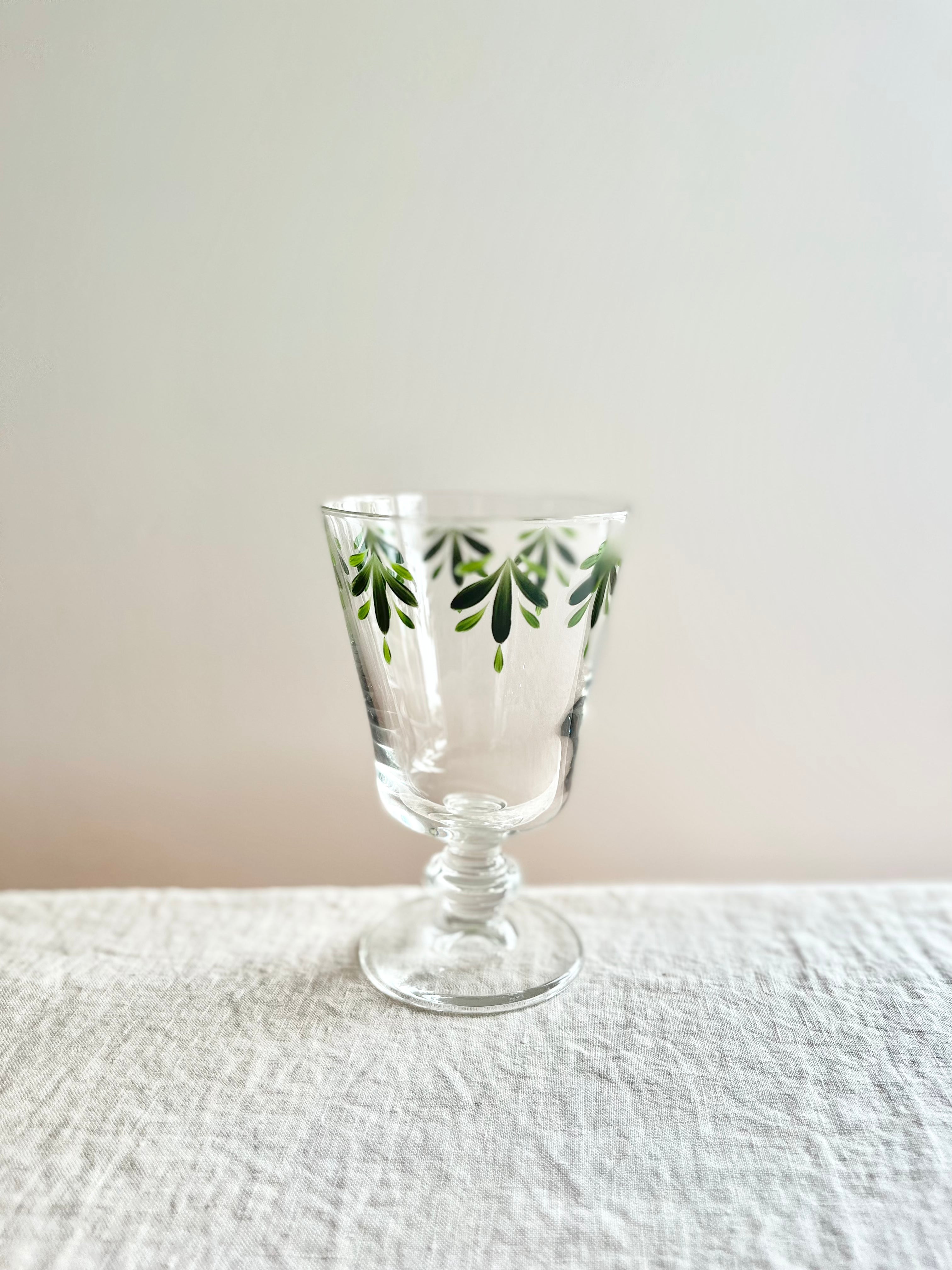 hand painted wine glasses with dark green leaf pattern on linen