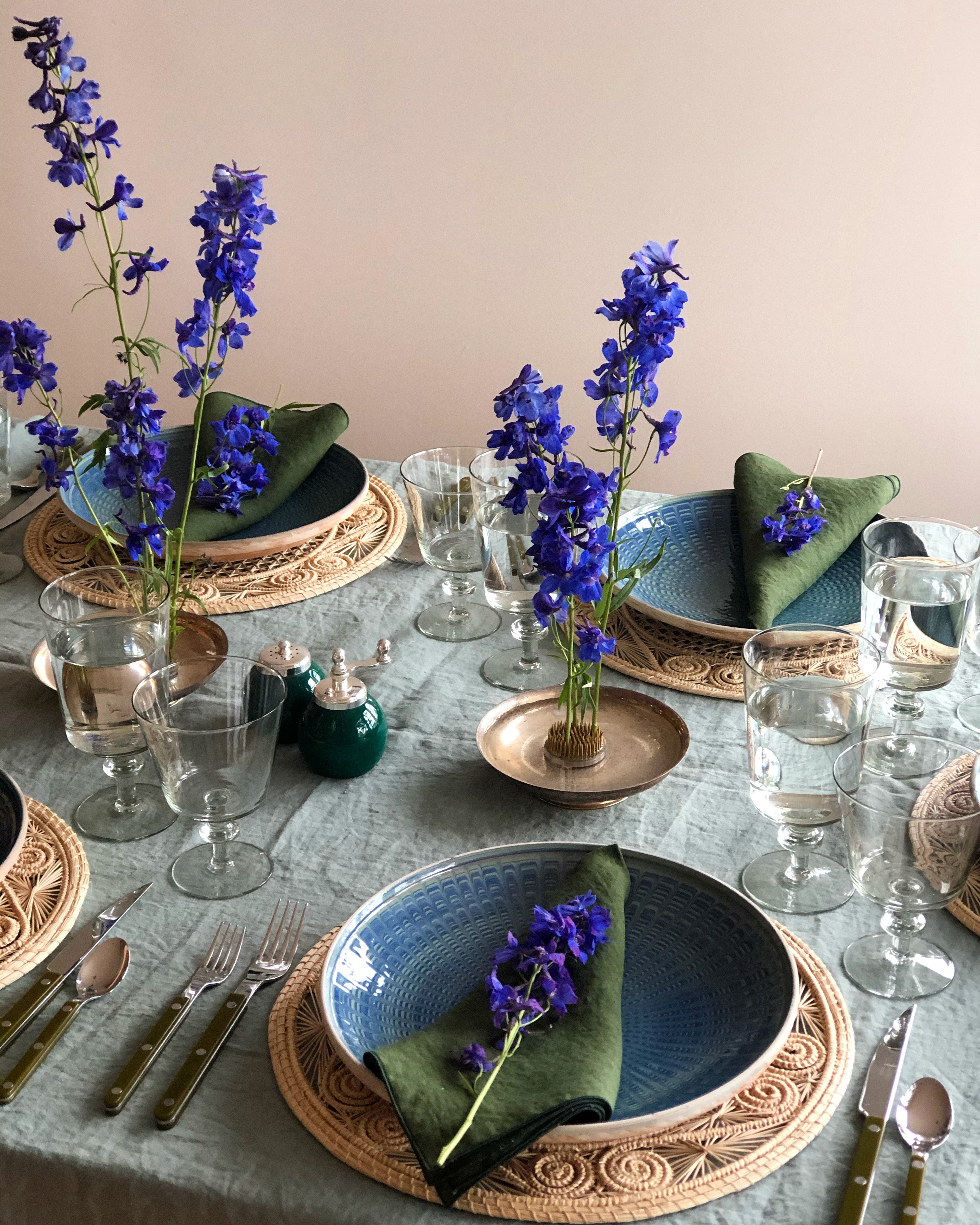 teal and green dinner plate with radial peacock pattern in placesetting