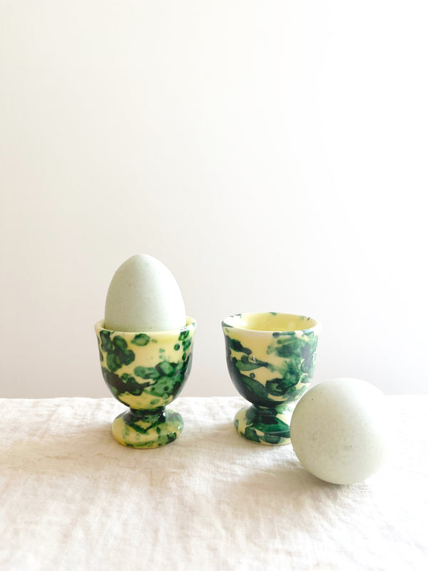 cream egg cups with green splatter pattern 2 inches in diameter with eggs