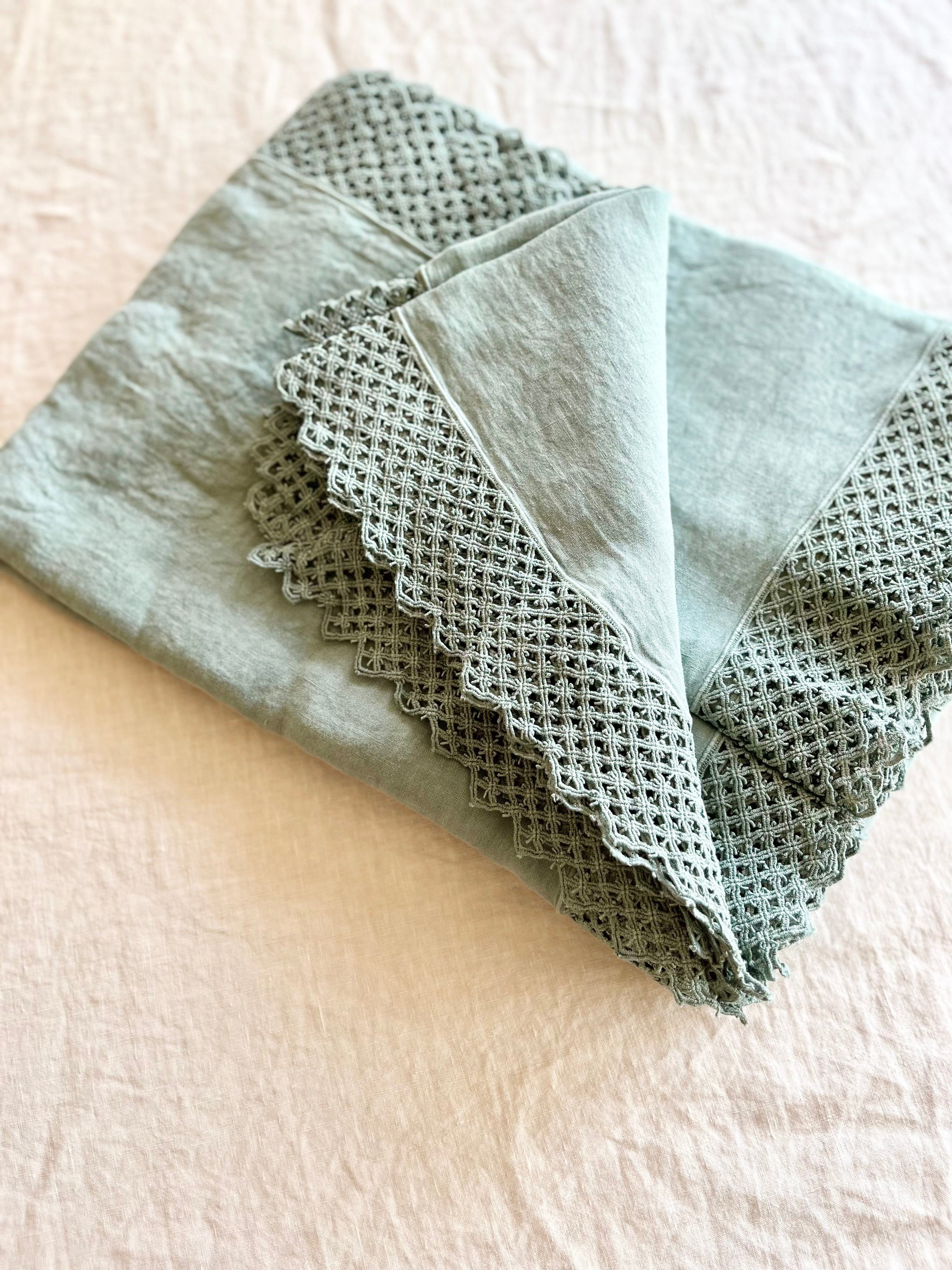 sage green linen tablecloth with macrame trim detail view