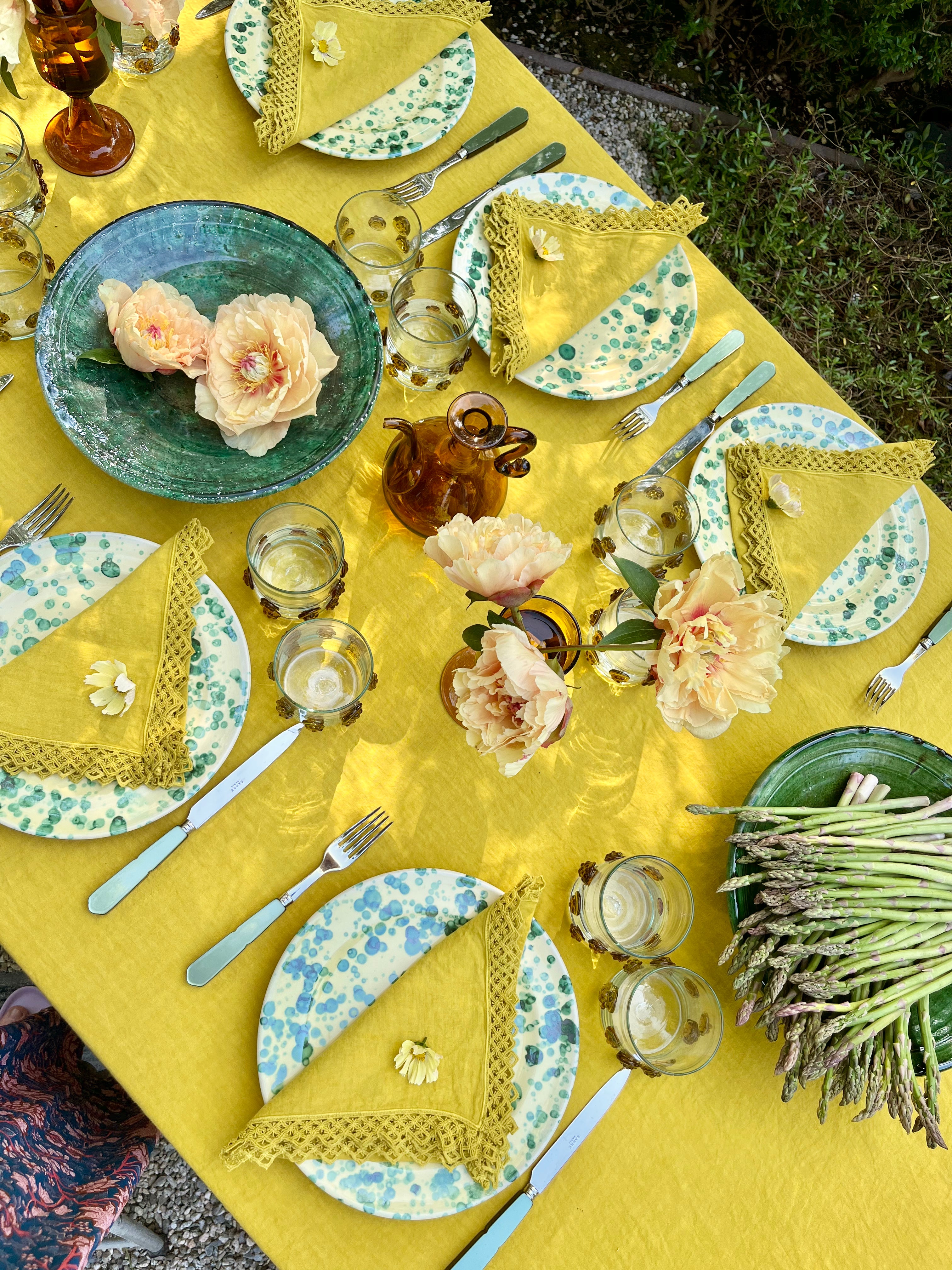 Yellow Milano Macrame Tablecloth shown on table outside from top view angle