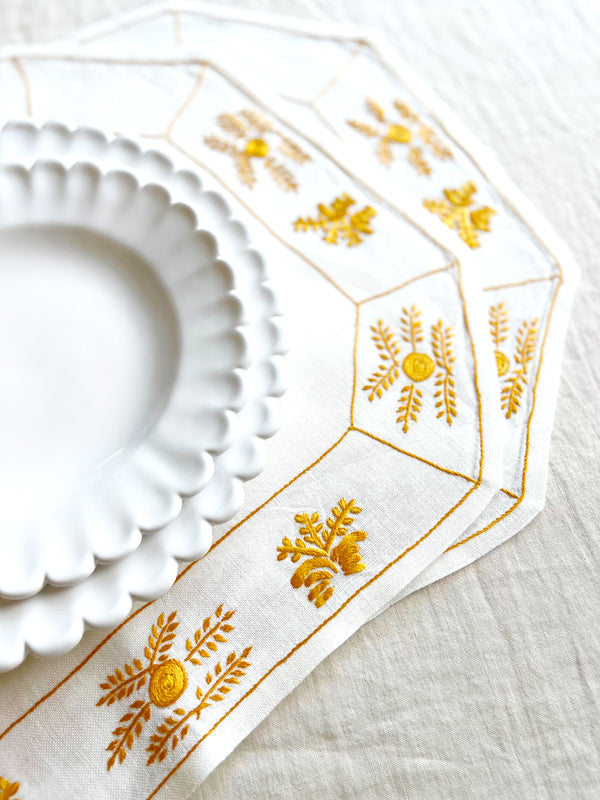 hand painted white salad plate with scalloped edge on yellow placemat