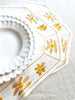 hand painted white salad plate with scalloped edge on yellow placemat