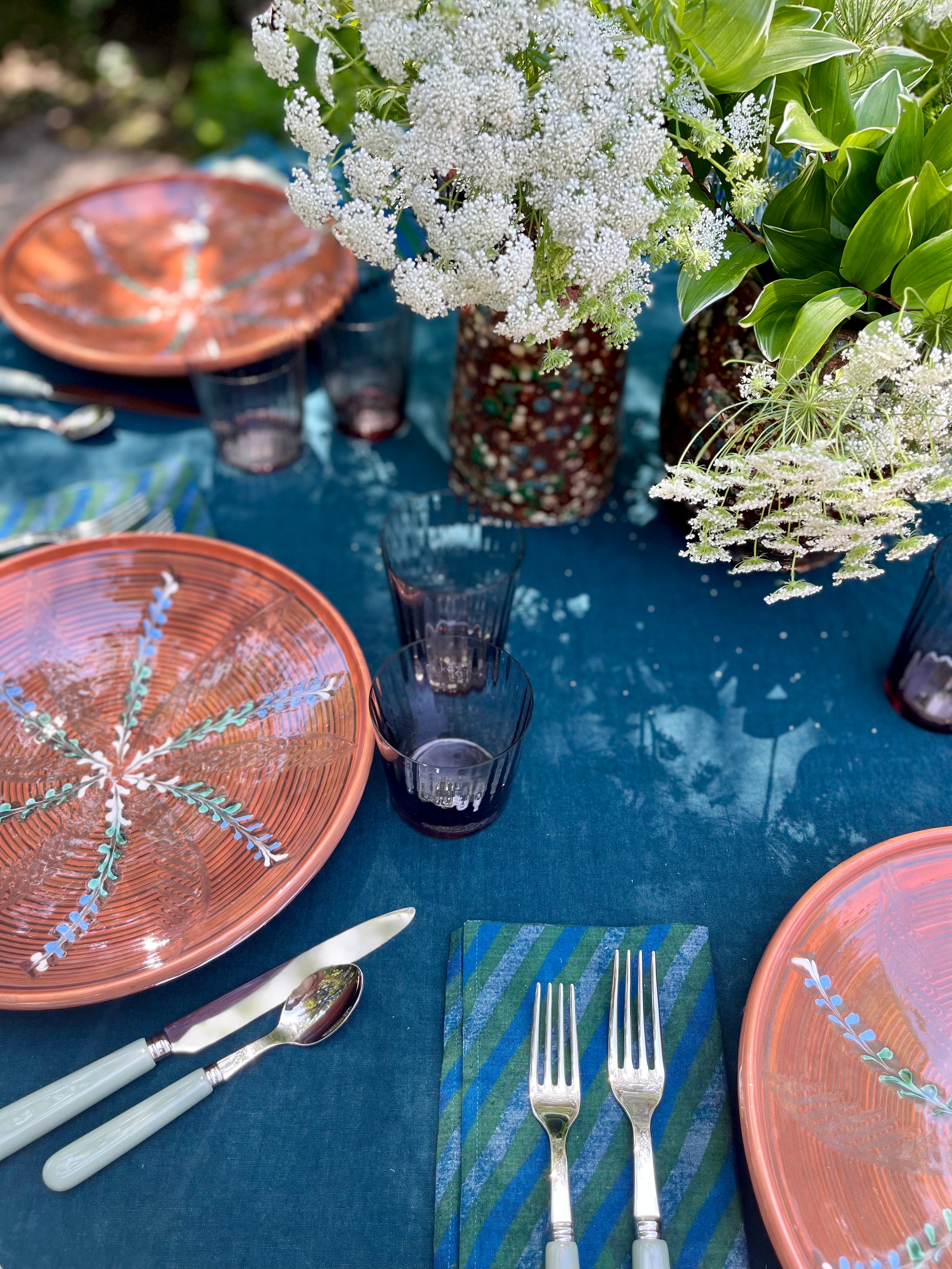 teal linen tablecloth with macrame trim with portocale plate
