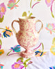 cream amphora vase with pink speckle pattern 13 inches tall on floral cloth