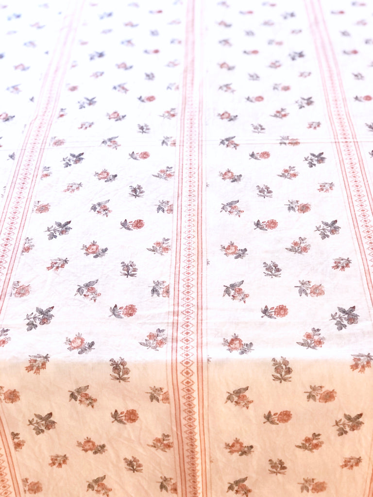 white tablecloth with red pinstripe and red floral pattern detail view