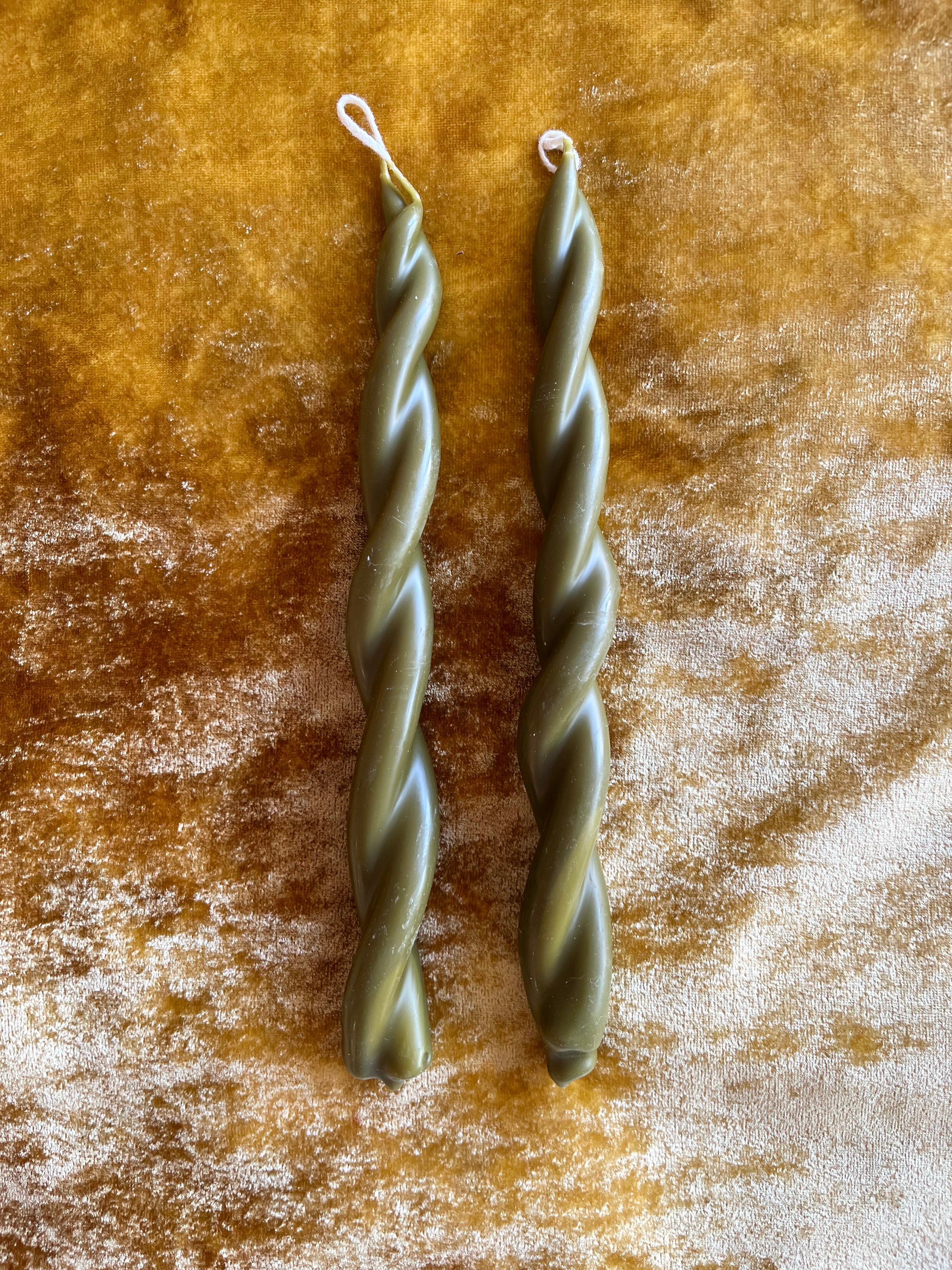 moss green twisted taper candles by wax atelier on gold velvet
