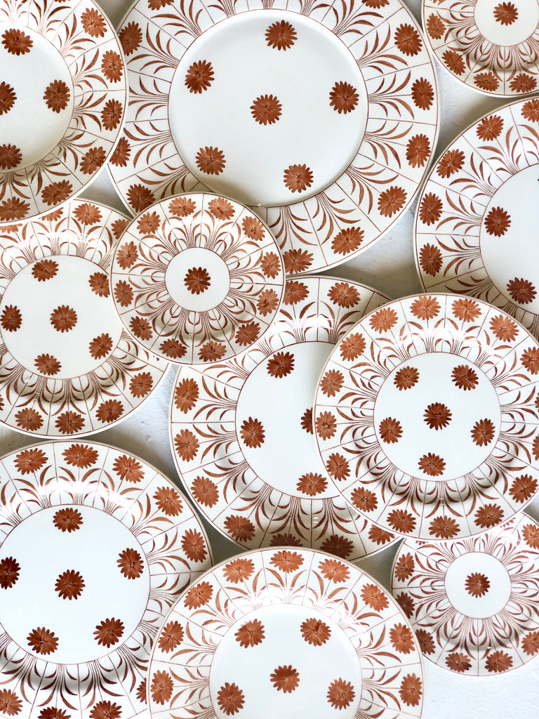 white ceramic dinner plate with brown daisy pattern in group
