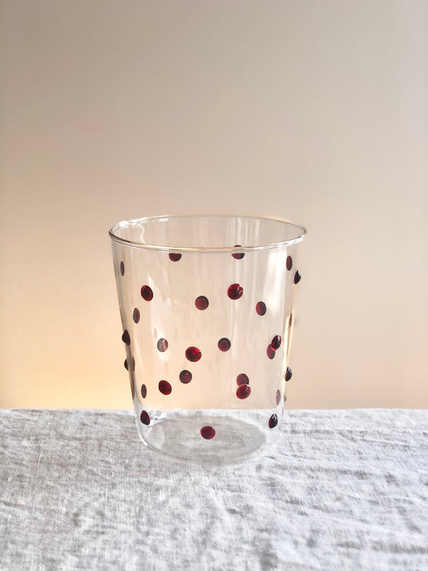 clear glass tumblers with red glass dots on table