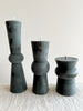 dark green totem candles large medium and small displayed on a table