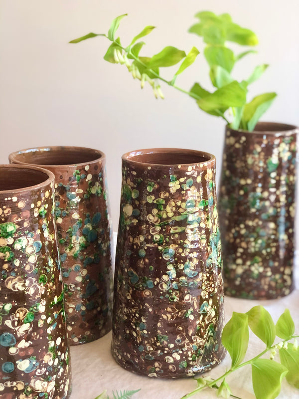 brown cylinder vases with green and cream speckle pattern 8.5 inches tall in group of four