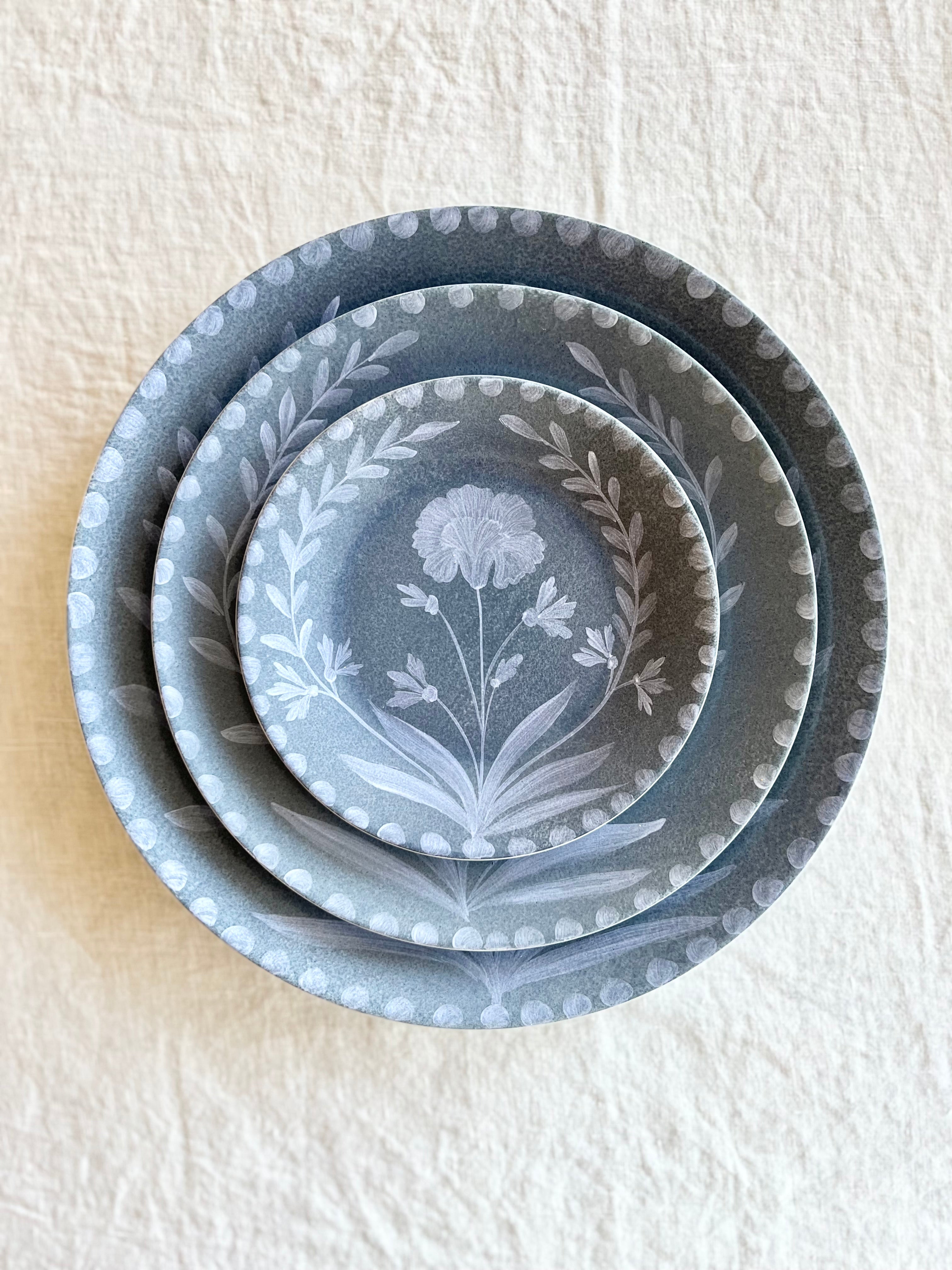 blue dinner plate with white floral pattern with bread plate and salad plate