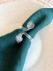 close up of clear glass napkin rings with folded napkin