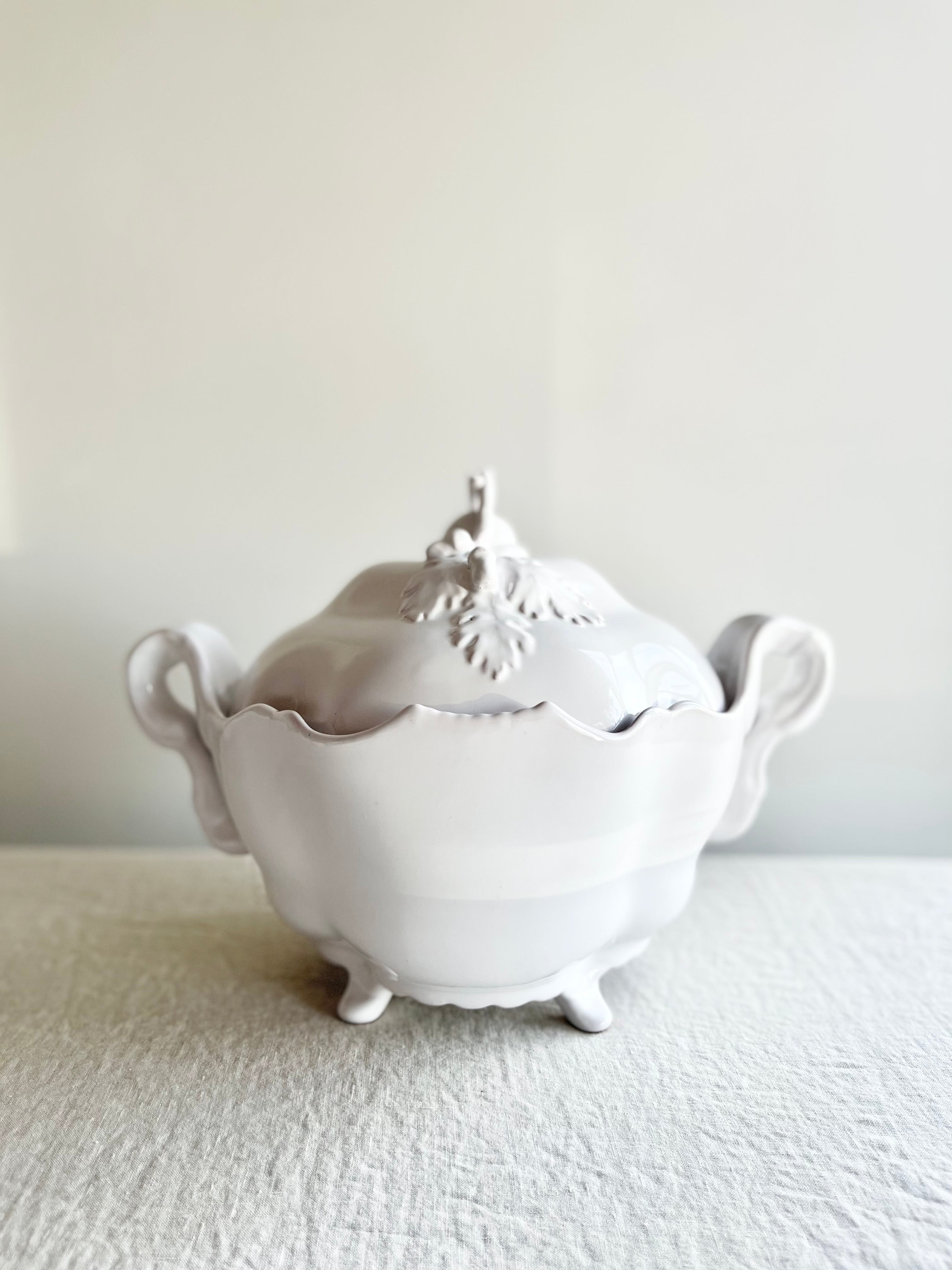 white soup tureen oak antique style close up on white tablecloth