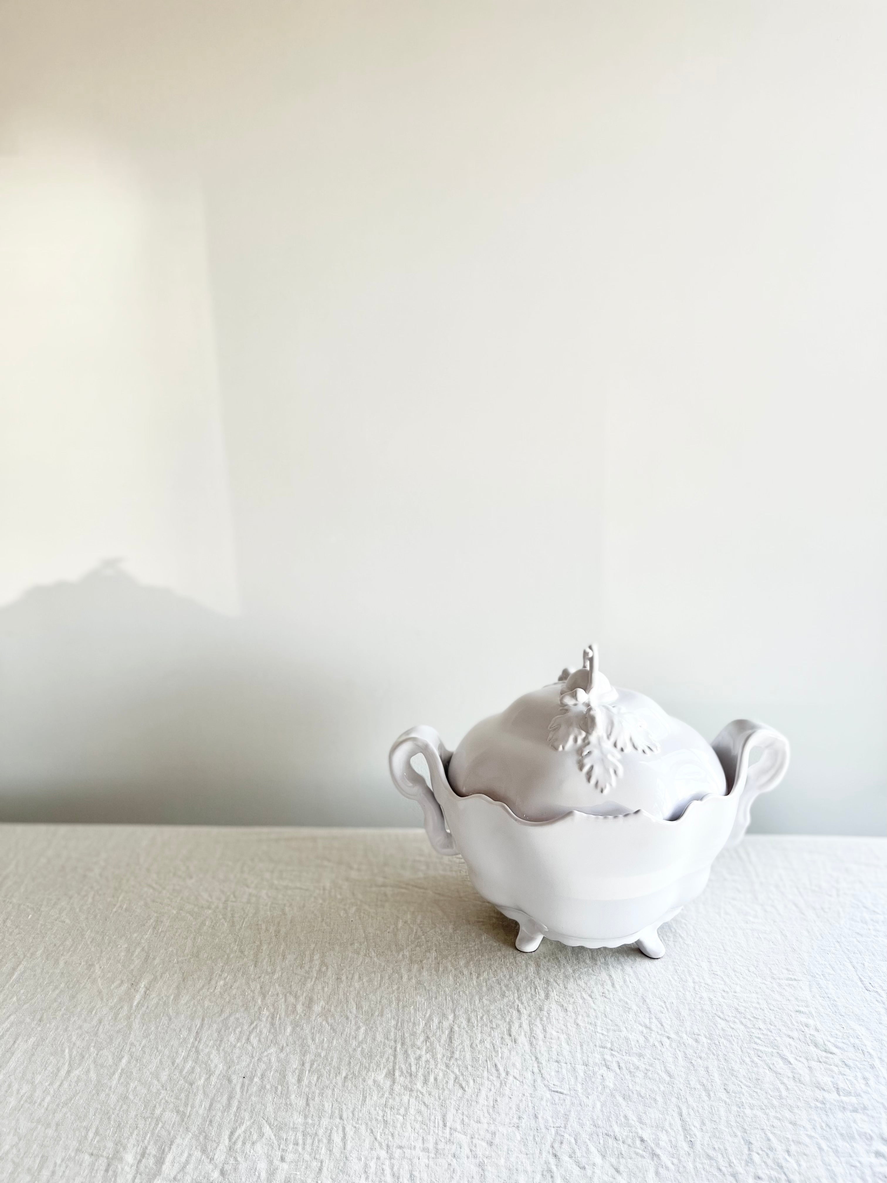 white soup tureen oak antique style on white tablecloth