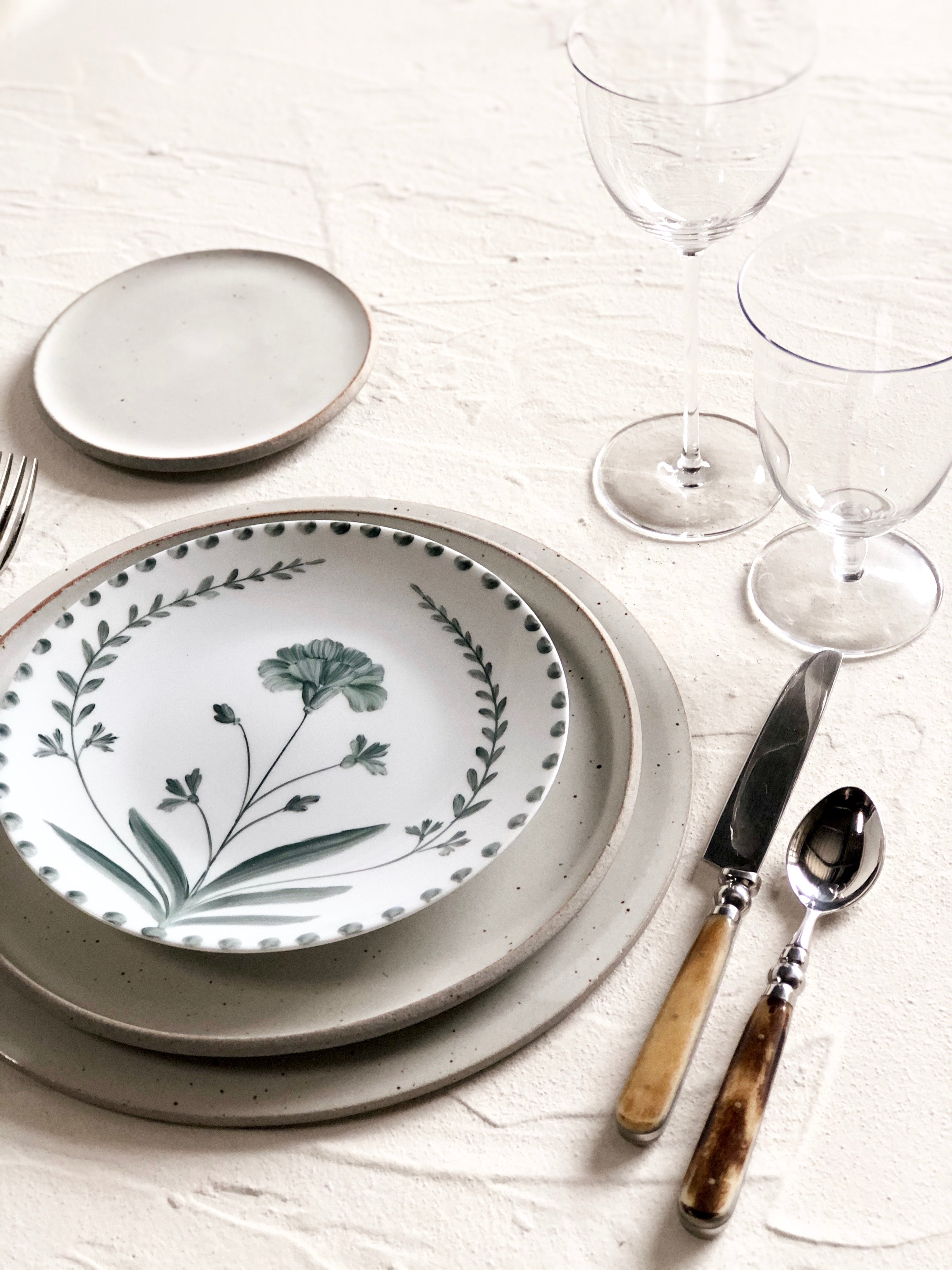 white salad plate with hand painted green floral design in placesetting