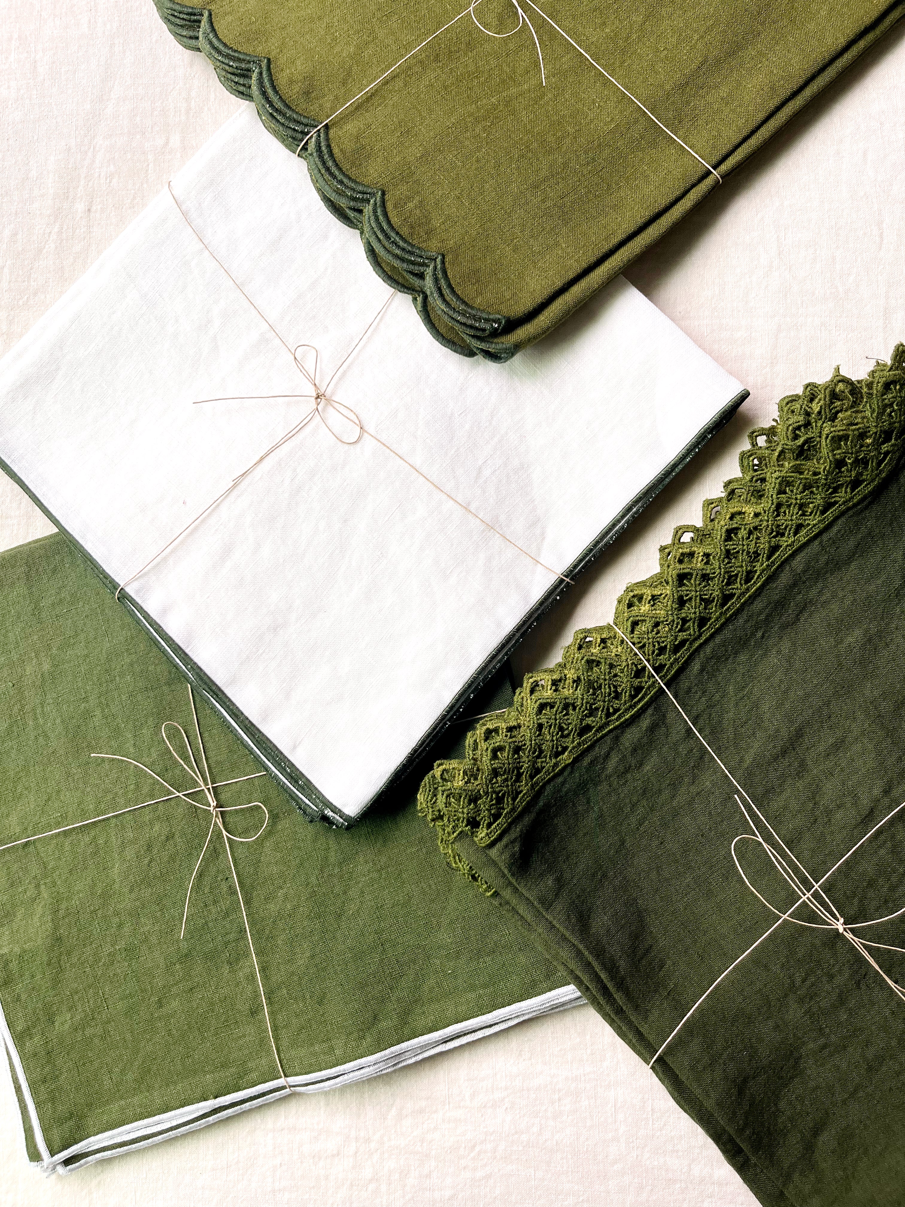 green linen napkins with macrame trim on white tablecloth