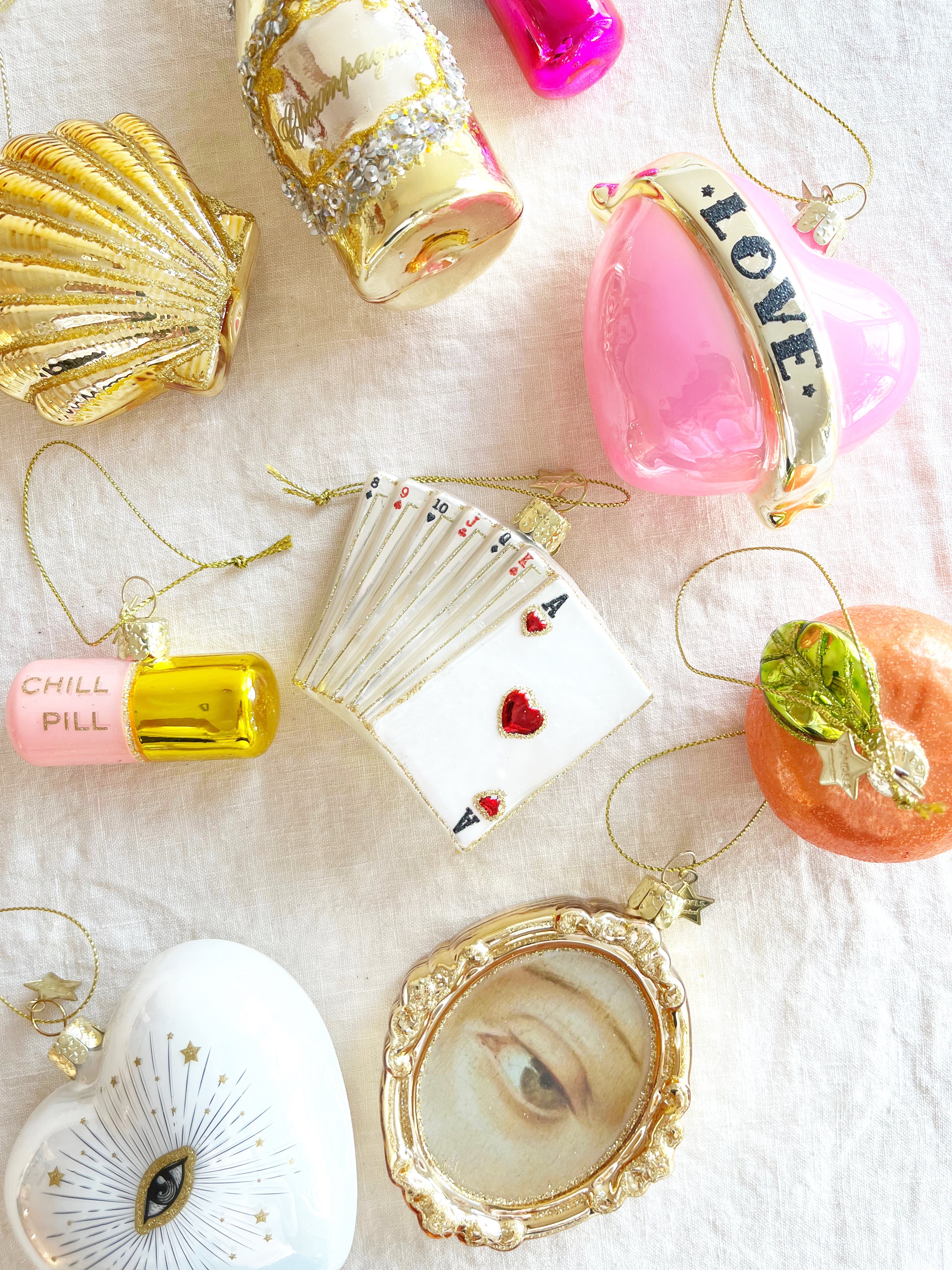 pink and purple glass christmas ornament shaped like a capsule with chill pill written on side in group with other ornaments