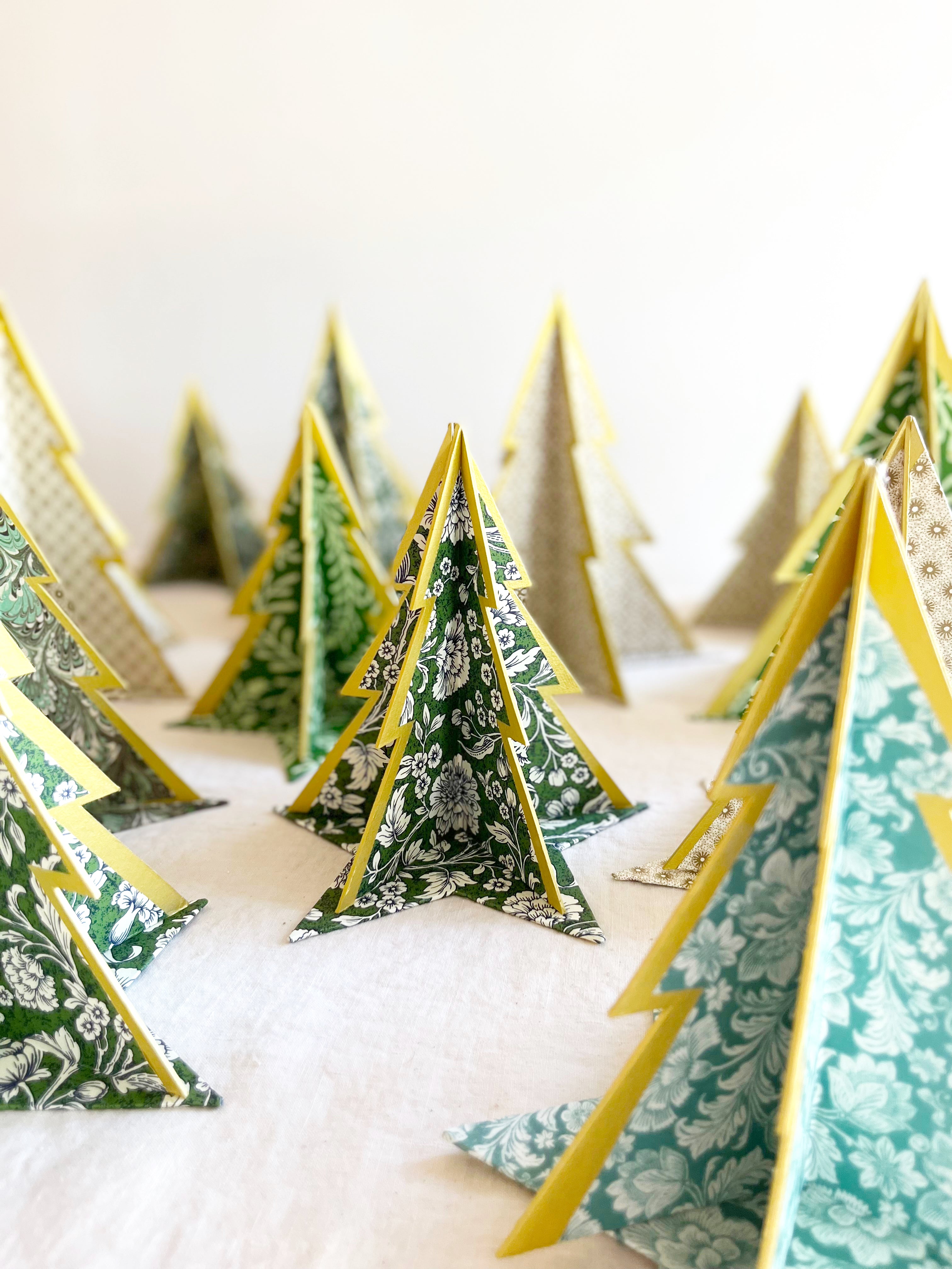 decorative paper christmas tree stand with green floral pattern on linen tablecloth