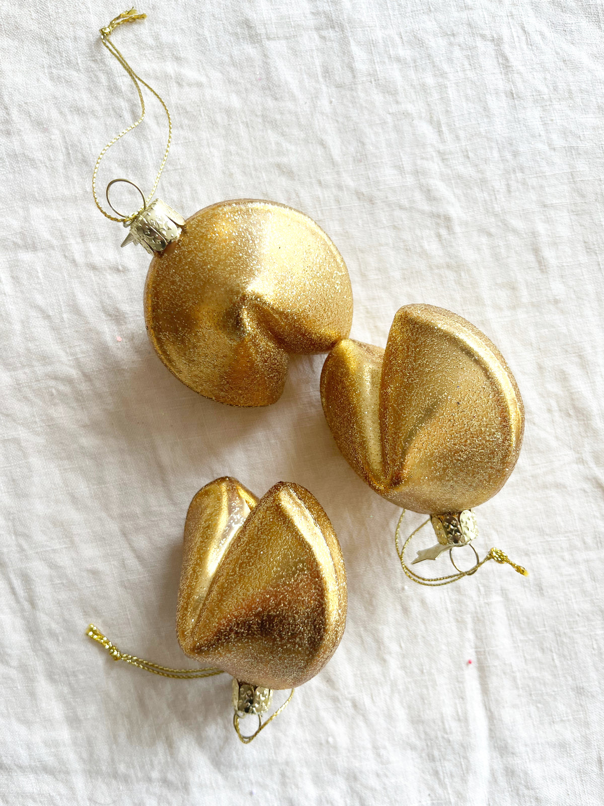 glass christmas ornament shaped like fortune cookie in group of three