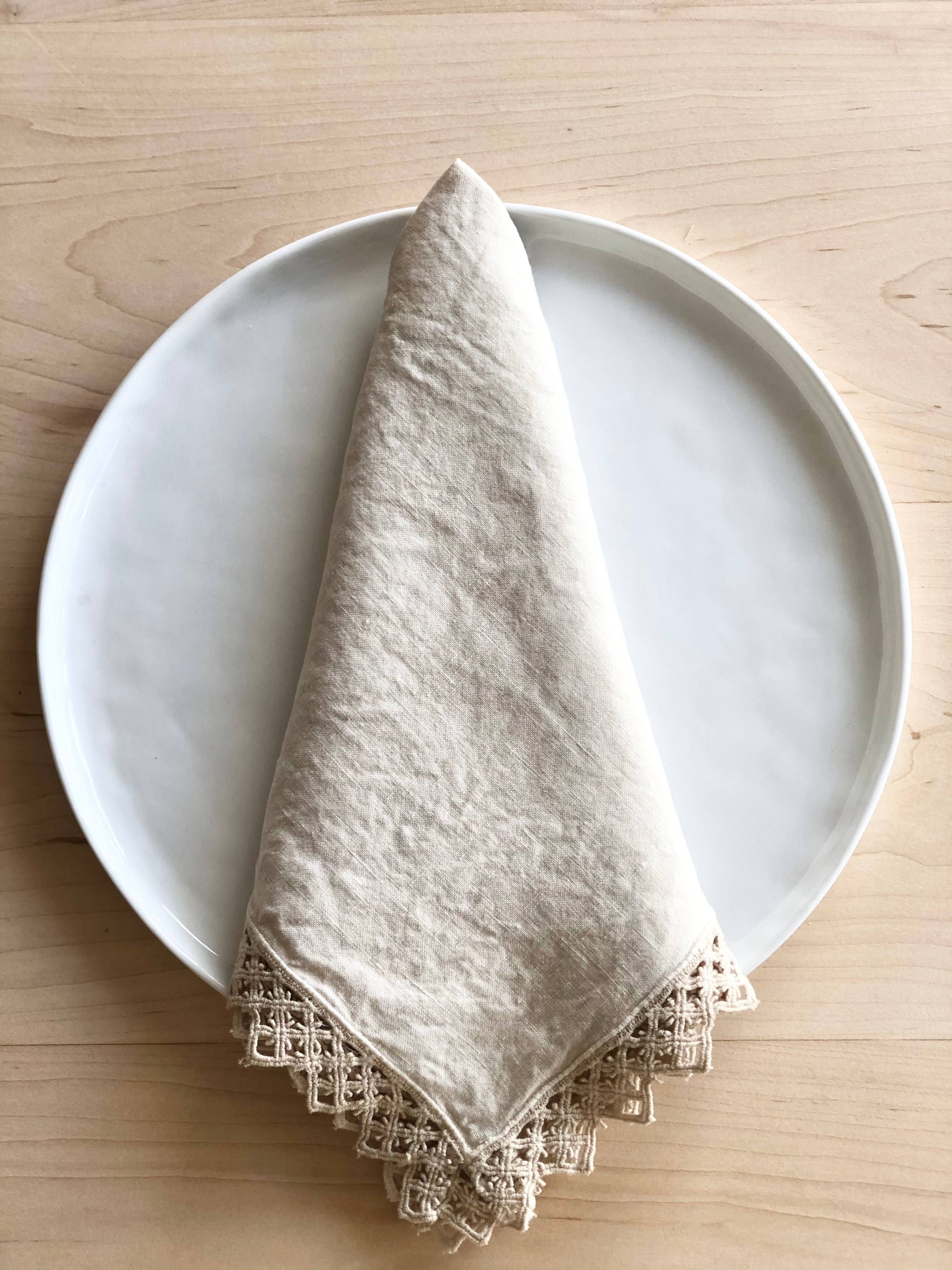 cream linen napkins with macrame trim on plate