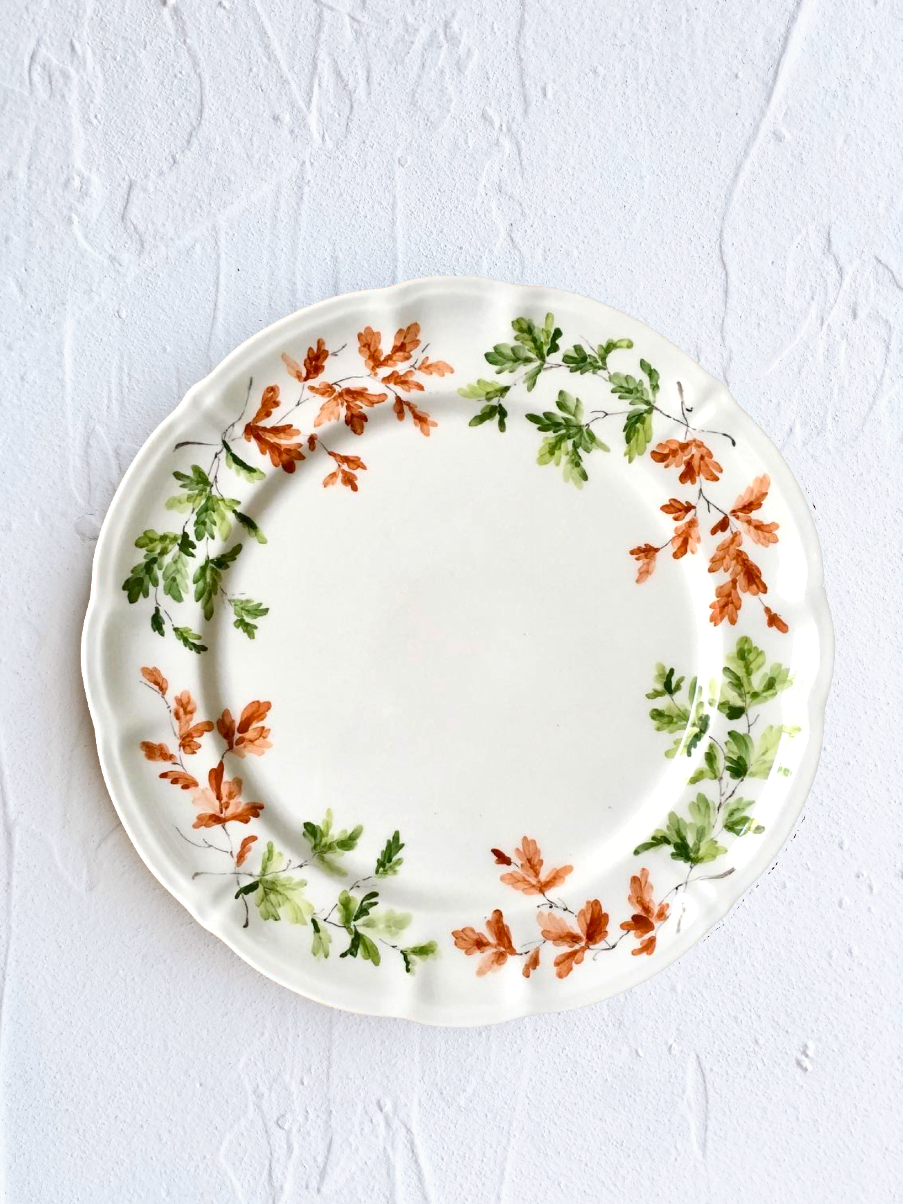 dinner plate with green and orange leaves on rim