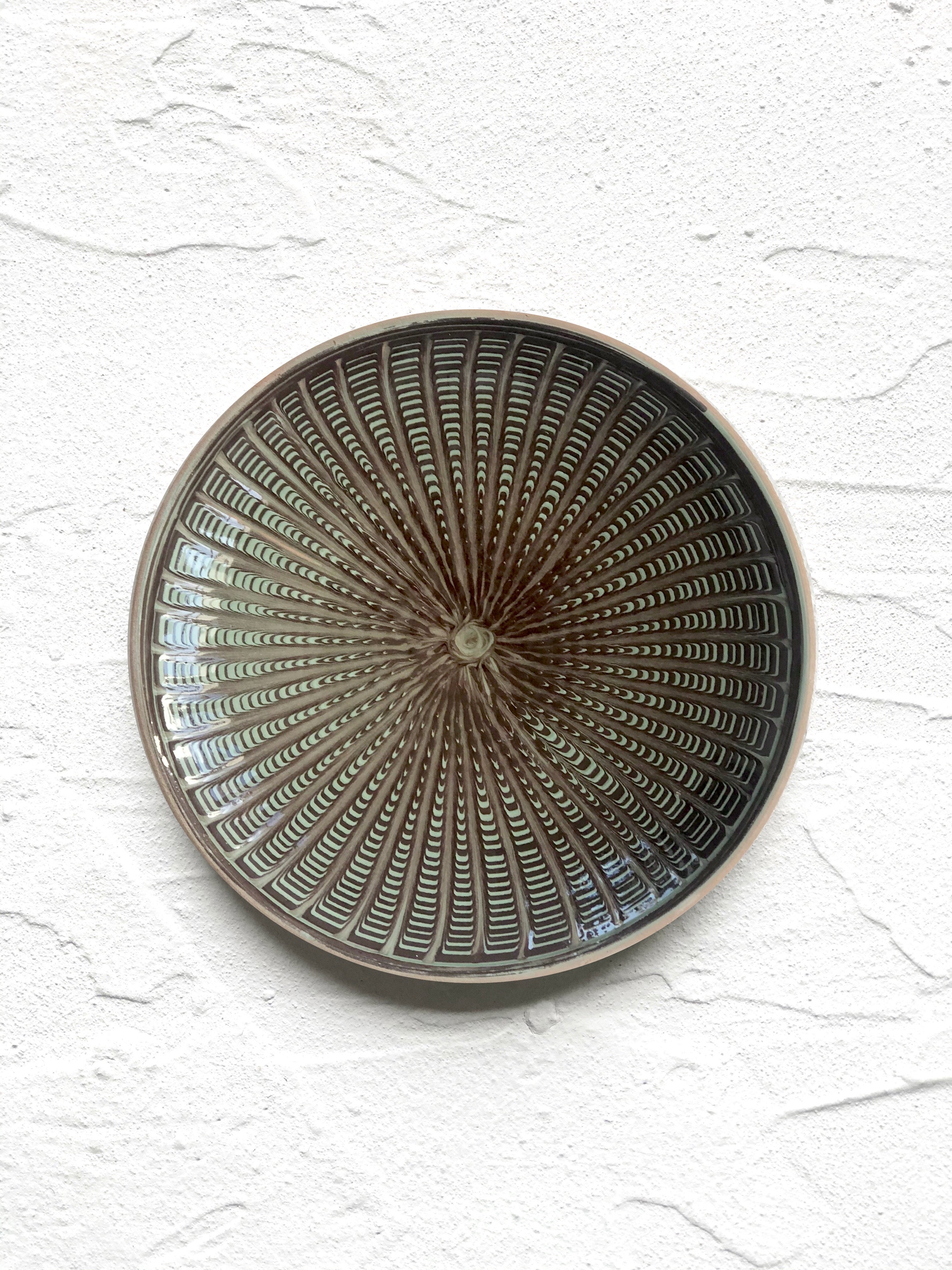green and black salad plate with radial peacock pattern