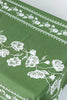 rectangular green embroidered tablecloth with white flowers