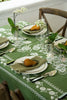 rectangular green embroidered tablecloth with white flowers on table