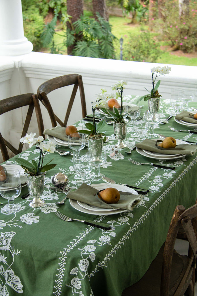 rectangular green embroidered tablecloth with white flowers on porch