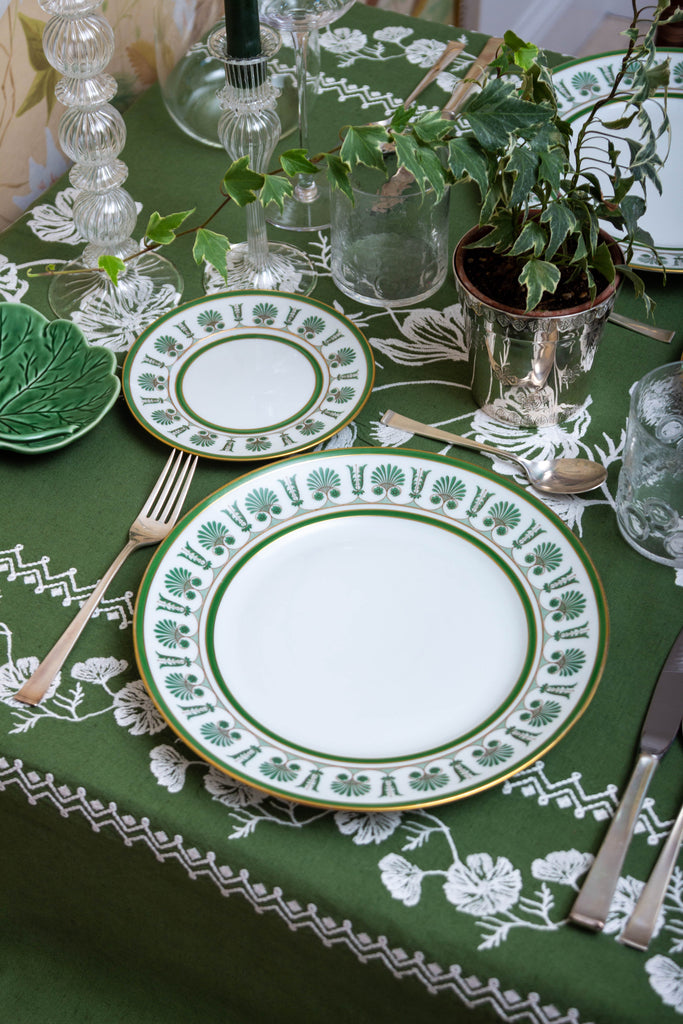 rectangular green embroidered tablecloth with white flowers with china