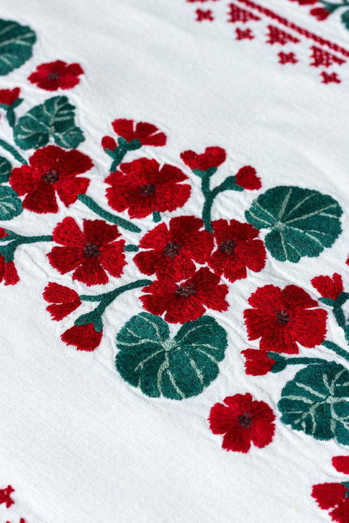 rectangular white embroidered tablecloth with red flowers detail view