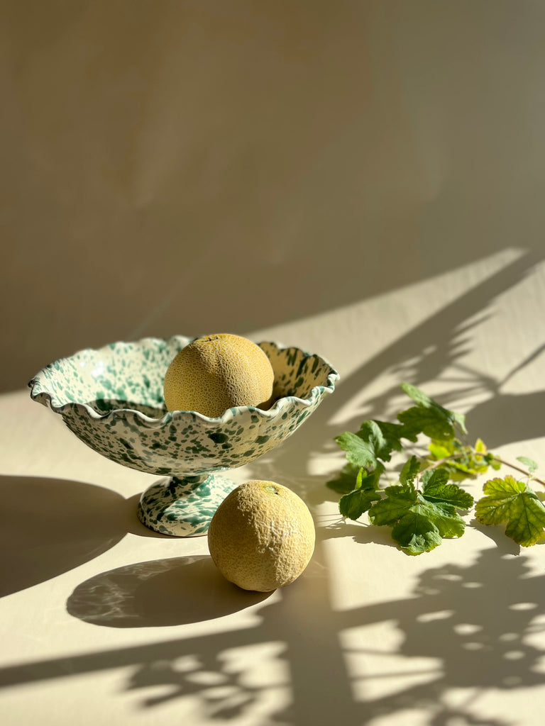 green and white spatterware compote bowl with two grapefruits