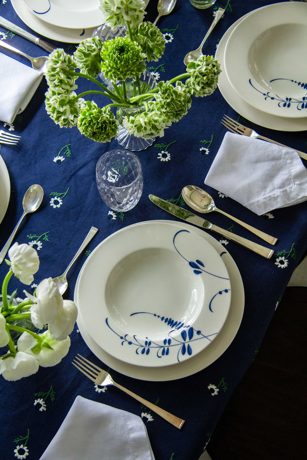 rectangular blue tablecloth with white daisies on table