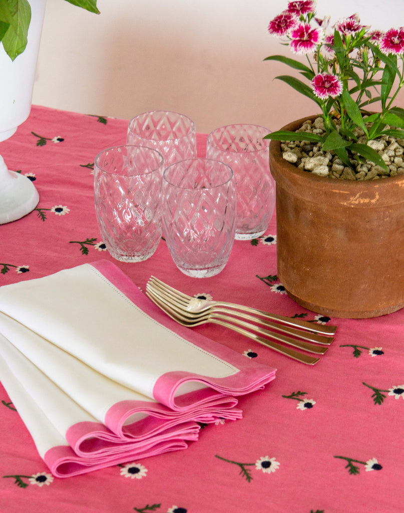 rectangular pink tablecloth with white daisies and flowers