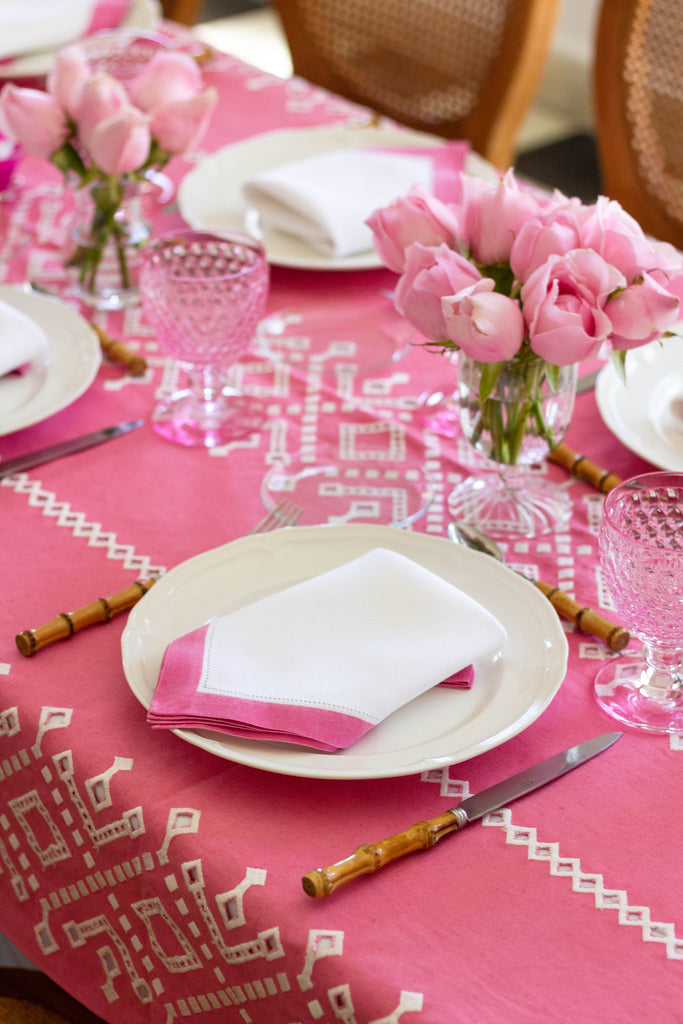 rectangular pink and white eyelet tablecloth with table setting