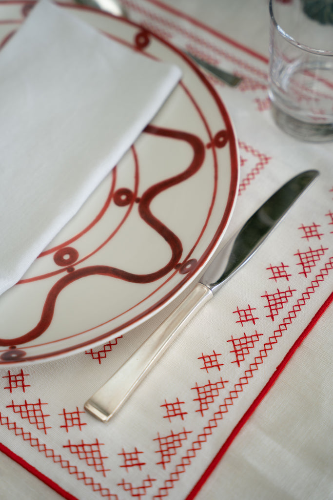 rectangular ivory and red embroidered placemat with placesetting