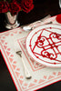 rectangular ivory and red embroidered placemat on table