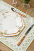 rectangular ivory and green embroidered placemat on wooden table